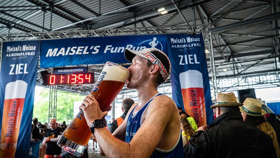 Jan Kundoerfer Pokal Maisels FunRun 2025 Sieger Jan Kundörfer trinkt aus dem riesigen Pokal.