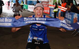 Jan Kundörfer vom Laufteam Bayern durchläuft das Zielbanner.