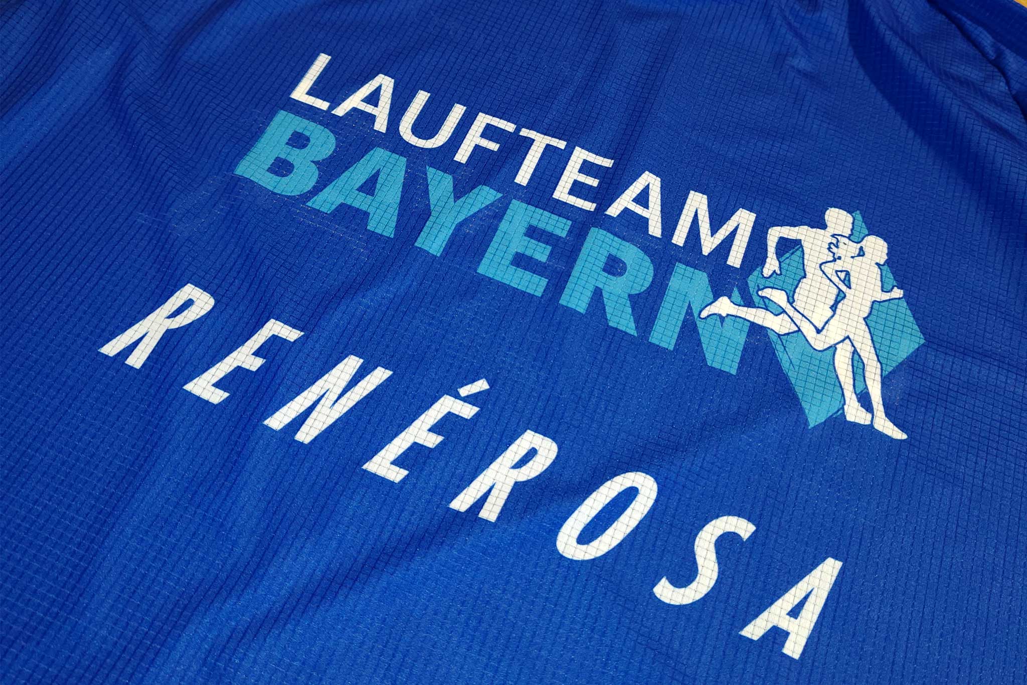 Die Logos von Laufteam Bayern und unserem Exklusivausrüster Renèrosa auf einem Raceshirt.